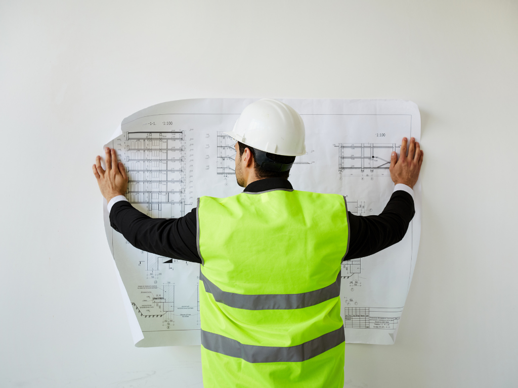 Construction worker holding a blueprint against a wall; MCAT study plan